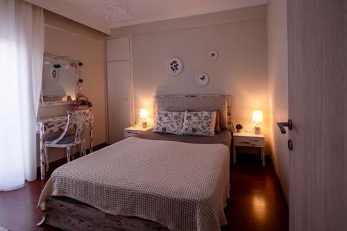 a bedroom with a bed and two tables and two lamps at Emi's beach apartment in Nea Kalikratia