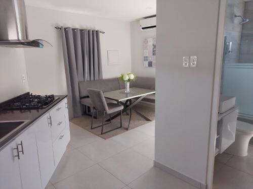 a kitchen with a table and a dining room at Apricity Suites Aruba in Noord