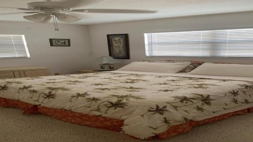 Un dormitorio con una cama grande con palmeras encima. en Go Fish Inn, en Big Pine Key