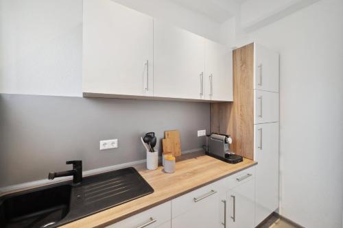 a kitchen with white cabinets and a sink at Ruhige Lage, gute Anbindung, frisch renoviert in Fellbach