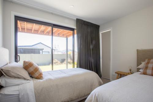 Un dormitorio con dos camas y una gran ventana. en Super Central in Wanaka, en Wanaka
