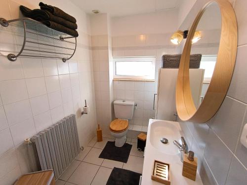 une salle de bain avec toilettes, lavabo et miroir dans l'établissement Ty Porzh, à Porspoder