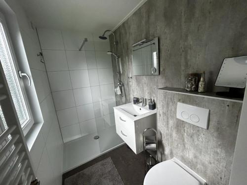 y baño con aseo, lavabo y ducha. en Ferienhaus / Chalet / Bungalow am See, Holland, Niederlande, Lathum en Lathum