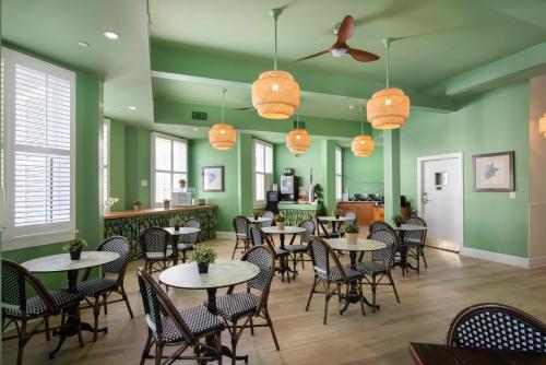 um restaurante com mesas e cadeiras e paredes verdes em Southernmost Inn Adult Exclusive em Key West
