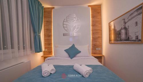 a bedroom with a bed with two towels on it at Хотел Терра Роза in Karlovo