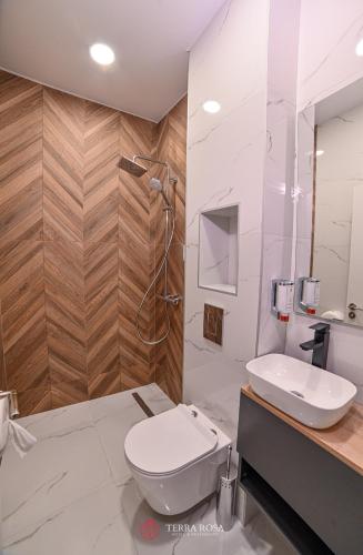 a bathroom with a toilet and a shower and a sink at Хотел Терра Роза in Karlovo