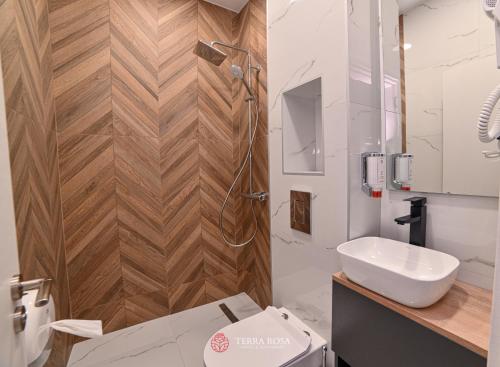 a bathroom with a white toilet and a sink at Хотел Терра Роза in Karlovo