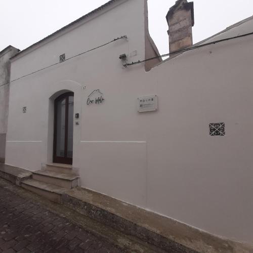 a white building with a door on the side of it at Casa MaLù 17 Cin I T 0 7 1 0 3 3 B 4 0 0 0 8 8 3 3 2 in Monte SantʼAngelo