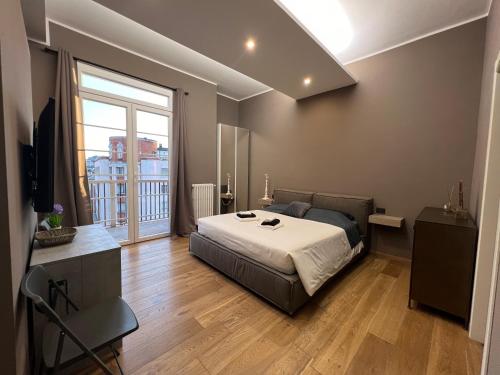 NEW AMAZING MONO LOCATED IN MOSCOVA DISTRICT from Moscova Suites apartments group في ميلانو: غرفة نوم بسرير ونافذة كبيرة