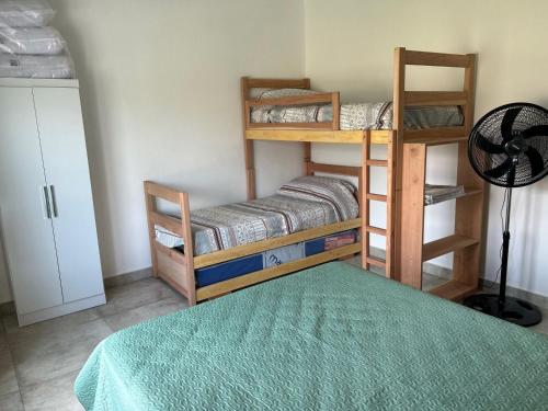 a room with two bunk beds and a green rug at Casa para 7 con pileta y parrilla in El Durazno