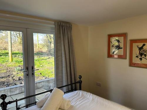 a bedroom with a bed and a large window at Sunnybank cottage in Alnwick