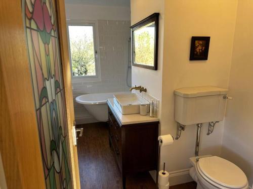 a bathroom with a sink and a toilet and a tub at Sunnybank cottage in Alnwick