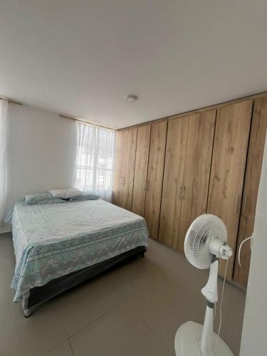 a bedroom with a bed and a white fan at CASA AMOBLADA CERCA A LA BASILICA in Club del Comercio