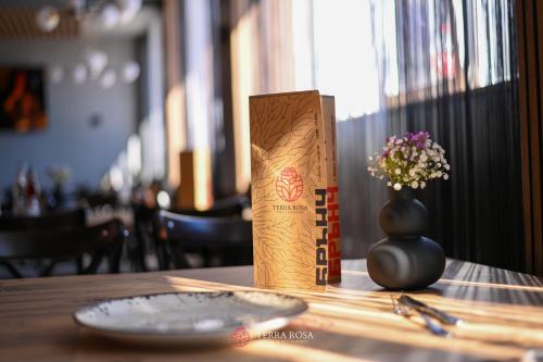 a box on a table next to a vase with flowers at Хотел Терра Роза in Karlovo