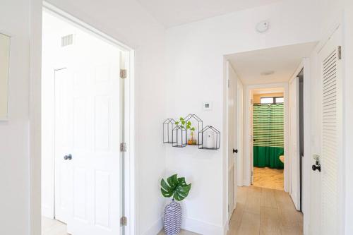 a hallway with white walls and a vase with a plant at Bay Harbor Unit 4 Perfect 2 Bed 1 Bathprime Lo in Miami Beach