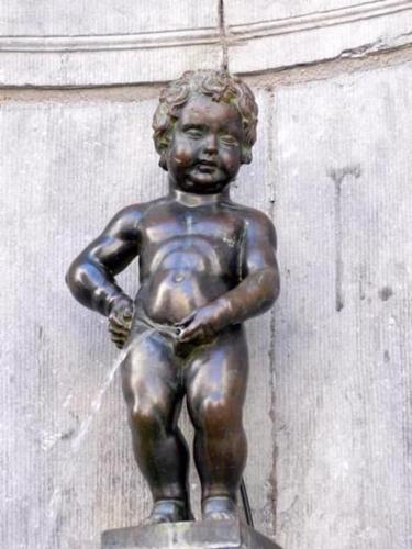 a bronze statue of a boy holding a clock at Charleville C centre - gare - aéroport in Charleroi