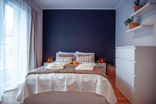 a bedroom with a large bed with blue walls at Apartament Słoneczny in Kwidzyn