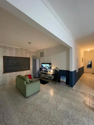- un salon avec un canapé vert et une télévision dans l'établissement Hostel Baltazar, à Fortaleza