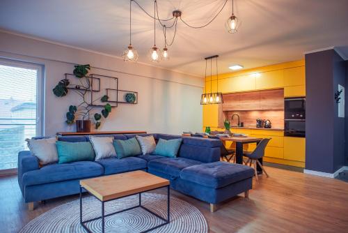 a living room with a blue couch and a table at Apartament Słoneczny in Kwidzyn