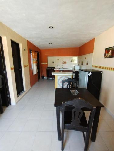 a kitchen with orange walls and a table in a room at Las Villas Champoton in Champotón