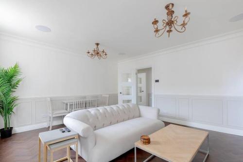 a living room with a white couch and a table at Elegant 3 Bed Flat in Marylebone, London in London