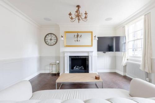 a living room with a white couch and a fireplace at Elegant 3 Bed Flat in Marylebone, London in London