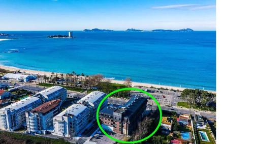 a building with a green circle around it next to the water at Playa Samil Vigo Reformado 2016 in Vigo