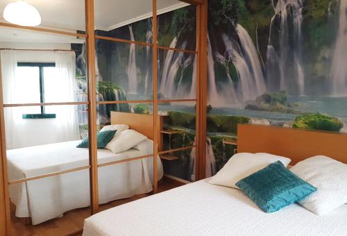 1 dormitorio con 2 camas y un mural con cascada en Playa Samil Vigo Reformado 2016 en Vigo