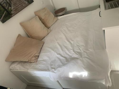een wit bed met twee kussens erop bij Studio de luxo no Porto - T0 in Porto