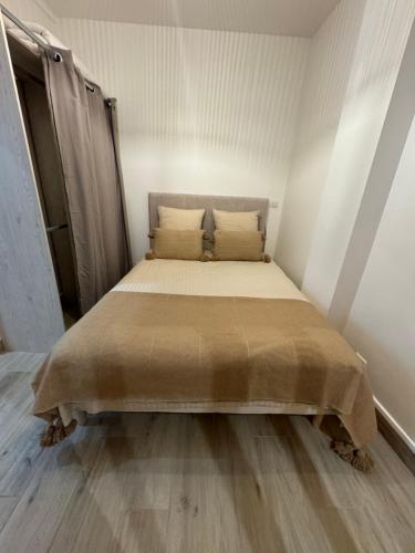 Appartement moderne au centre-ville في سان دوني: سرير في غرفة بيضاء وعليها مفرش