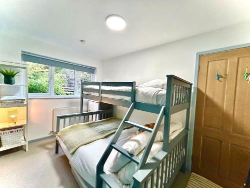 1 dormitorio con 2 literas y ventana en Bungalow, mountain and sea views parking, en Aberdyfi