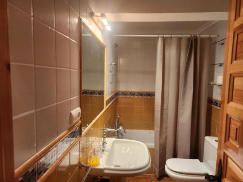 y baño con lavabo, aseo y espejo. en La casa sobre el rÍo, en Cuenca