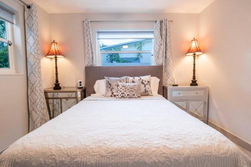 Wilton Manors Cottage West 2 Bed 2 Bath With Pool في فورت لاودردال: غرفة نوم بسرير كبير مع مواقف ليلتين