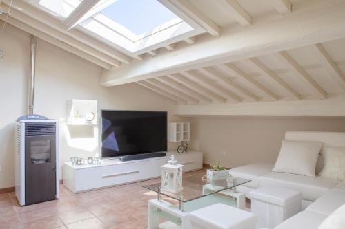 a living room with a white couch and a tv at White Attic Lucca in Lucca
