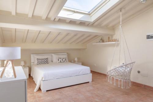 - une chambre avec un lit blanc et une balançoire dans l'établissement White Attic Lucca, à Lucques