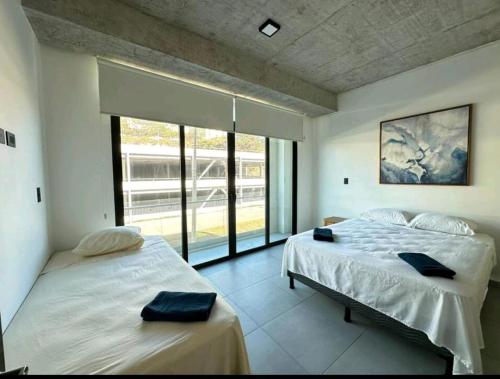 1 dormitorio con 2 camas y ventana grande en Spacious & Classy apartment in Santa Elena, en Antiguo Cuscatlán