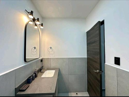 Spacious & Classy apartment in Santa Elena في Antiguo Cuscatlán: حمام مع حوض ومرآة