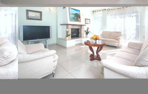 a living room with white furniture and a tv at Beautiful Home In Pula in Pula