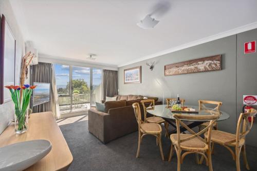 a living room with a table and a couch at Horizons 404 in Jindabyne