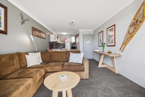 a living room with a couch and a table at Horizons 404 in Jindabyne