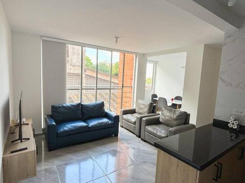 a living room with two chairs and a couch and a table at Moderno Apto 2HA, Central con Wifi5G in Ibagué