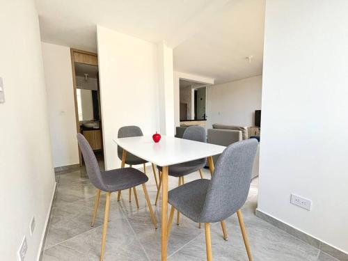 a dining room with a white table and chairs at Moderno Apto 2HA, Central con Wifi5G in Ibagué