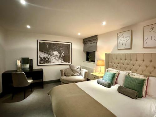 um quarto com uma cama grande e uma cadeira em Luxury 5 Bed all en-suite home with Hot tub em Hale