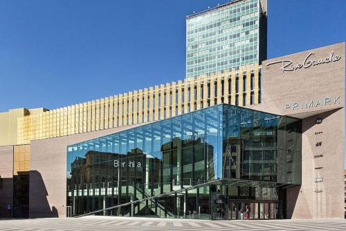 a large glass building with a tall building at Charleville E centre - gare - aéroport in Charleroi