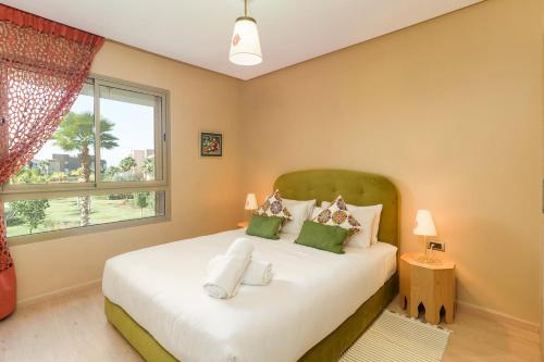 - une chambre dotée d'un grand lit avec des oreillers verts et blancs dans l'établissement Belle Vue piscine - Golf -Wi-Fi, à Marrakech