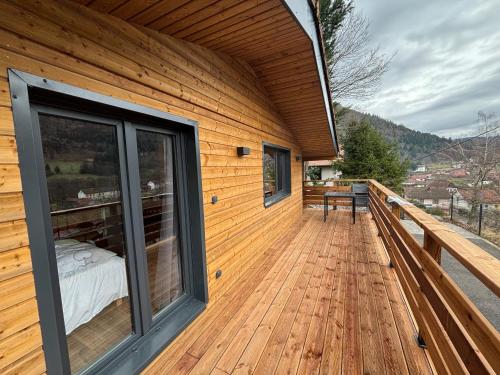 a large wooden deck with a bed on it at Chalet du Faubourg & Jacuzzi, proximité Gerardmer & La Bresse in Rochesson