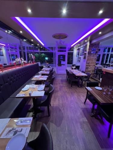 a restaurant with tables and chairs and purple lighting at ABBEY HOLIDAY ACCOMMODATiON in Whitby