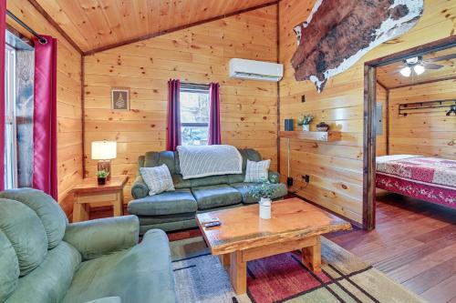 uma sala de estar com um sofá e uma mesa em Cabin with Expansive Deck about 4 Mi to Red River Gorge! em Rogers