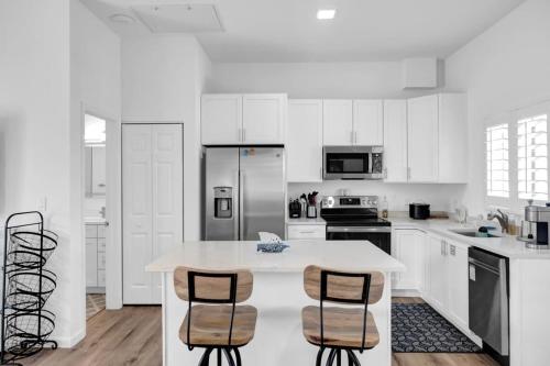 a kitchen with white cabinets and a table and chairs at Carney's Reef NEW 1B 1B Pool Patio in Marathon