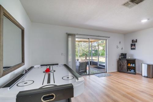 an empty living room with a ping pong table at Home with Screened Porch, Near Weeki Wachee Springs! in Spring Hill